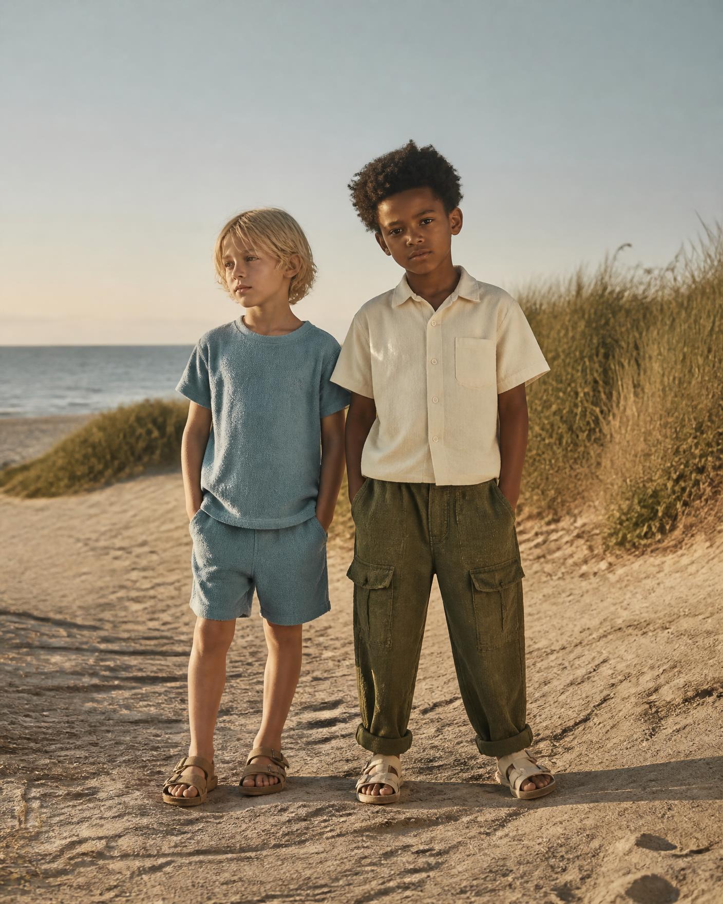 Two children in matching terry sets on a sunlit deck
